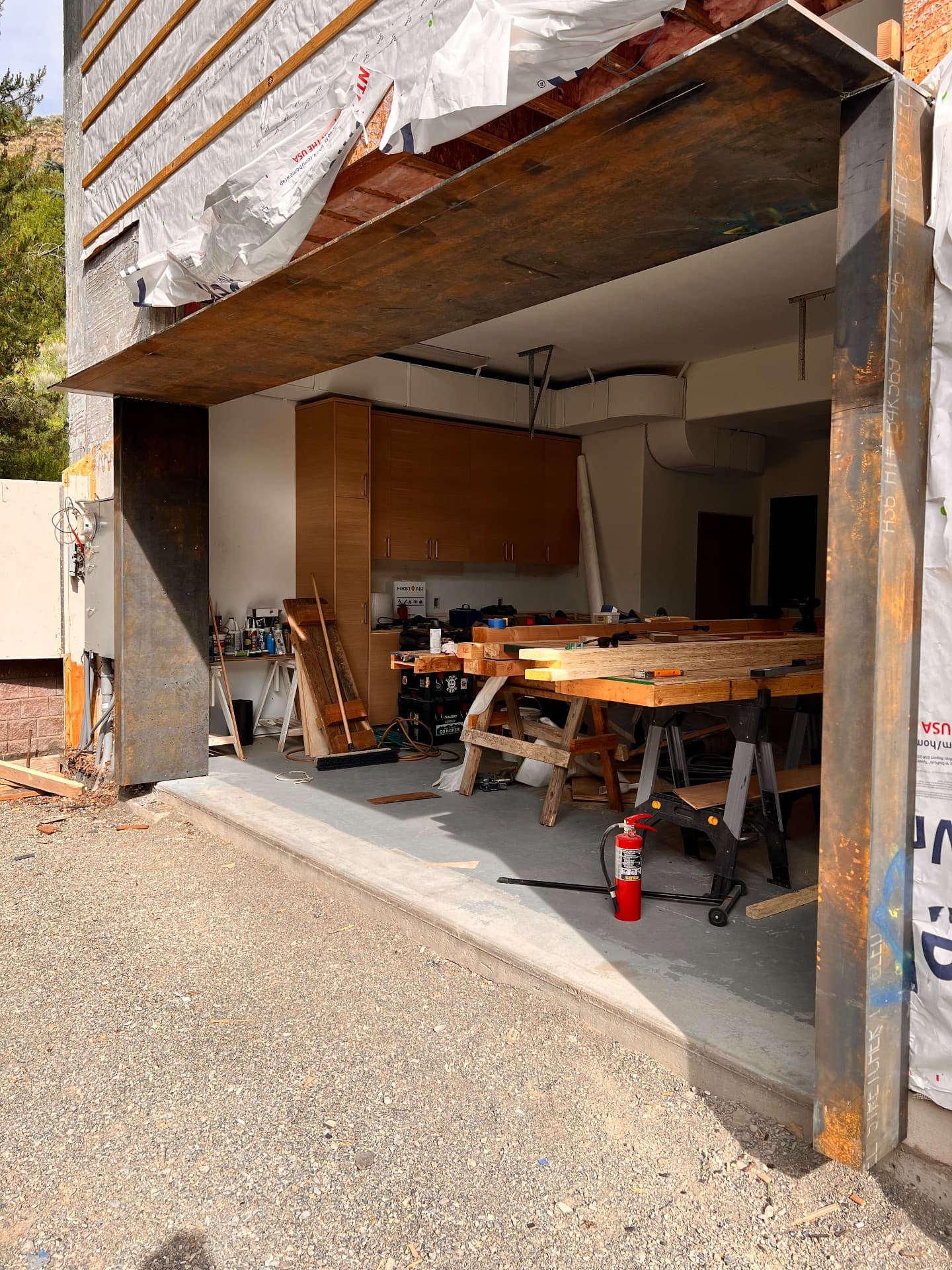 Large custom steel beam installed above an open residential garage entrance during construction