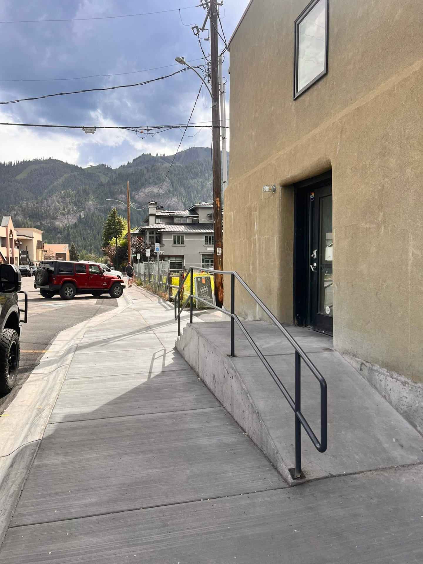 Black steel pipe handrail on concrete entry steps along a downtown Ketchum sidewalk