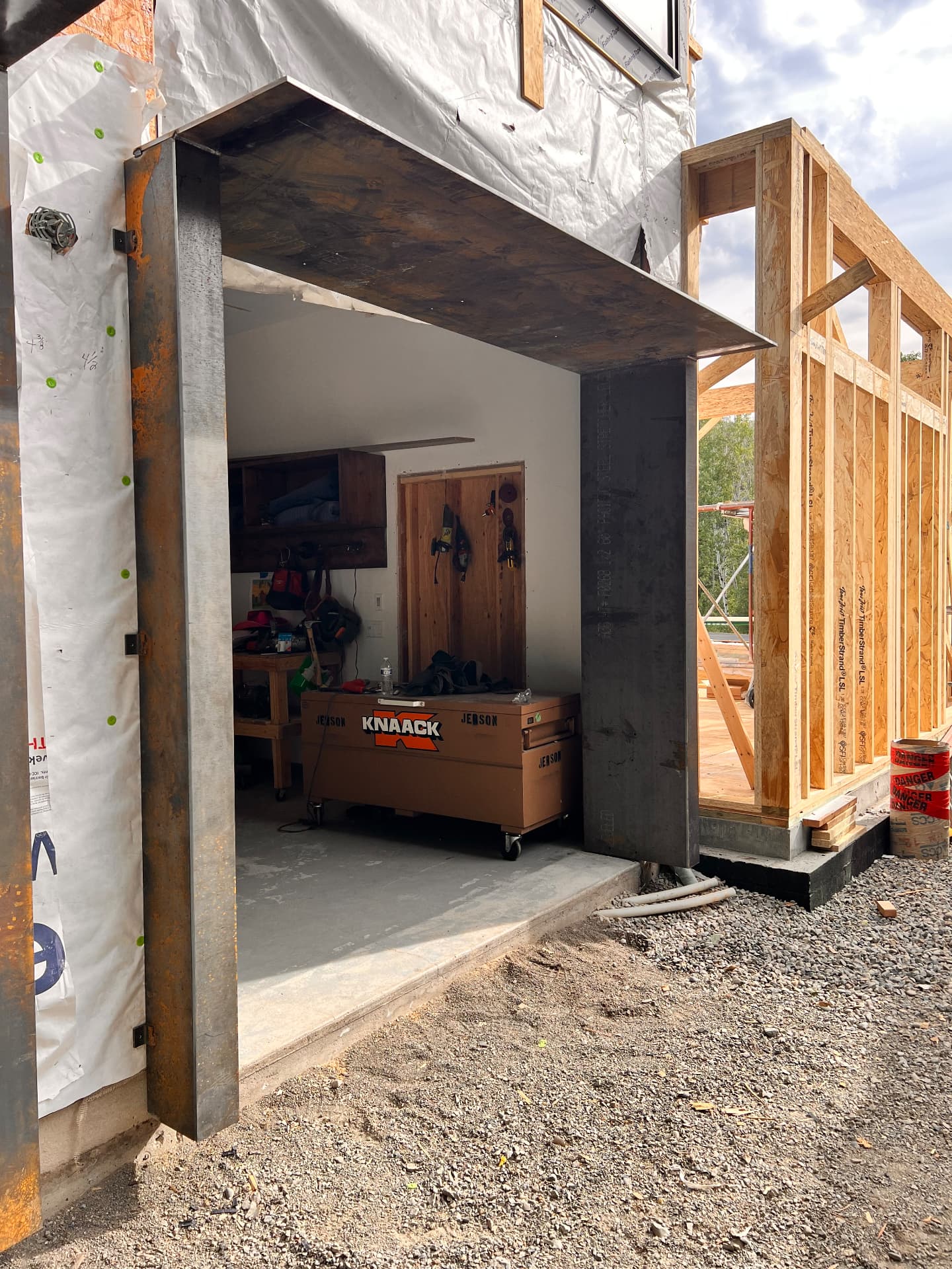 Weathering steel entry canopy with square steel posts built over a doorway at a residential jobsite