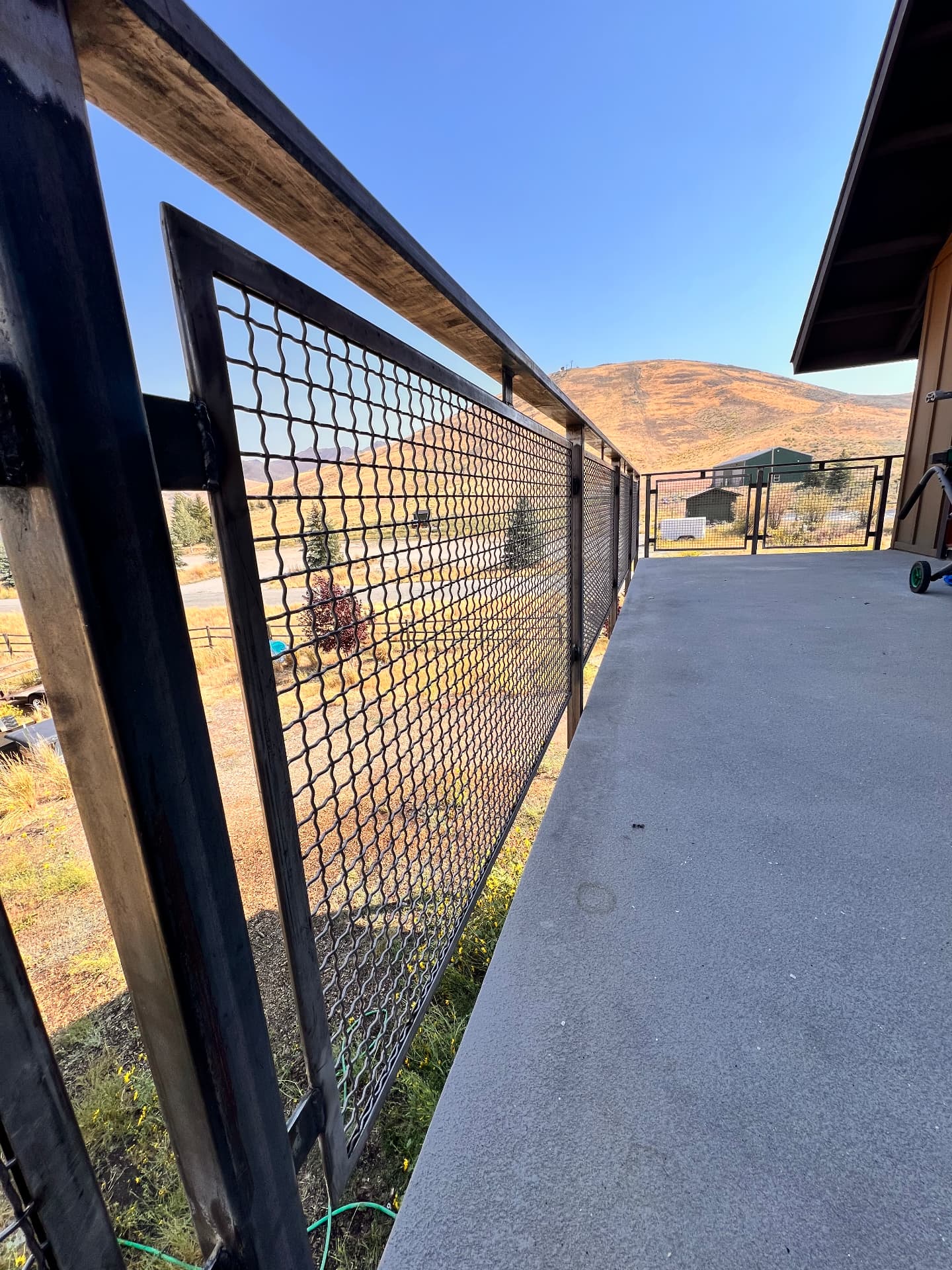 Close-up view of custom welded steel mesh railing along an exterior concrete deck